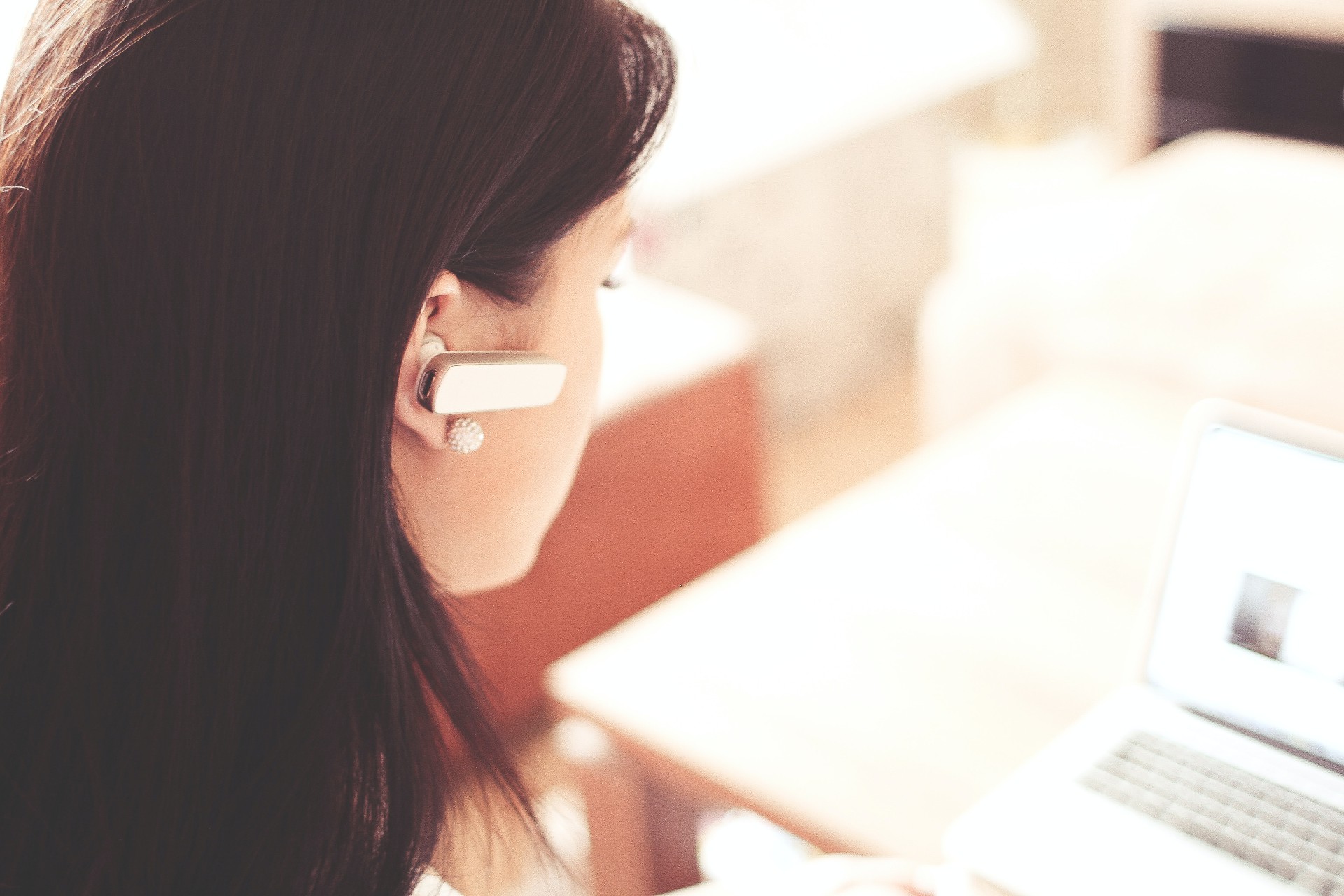 woman-wearing-earpiece-using-white-laptop-computer-210647.jpg
